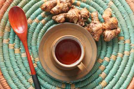 香草背景摄影照片_木制背景上的姜茶的顶视图。