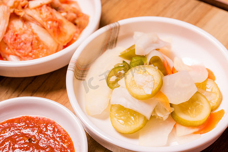榨萝卜汁摄影照片_韩国泡菜或腌萝卜蔬菜和调味碗