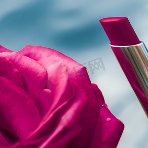 液体背景中的粉色口红和玫瑰花、防水魅力化妆品和唇彩化妆品产品，适用于豪华美容品牌假日设计