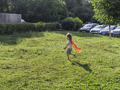 小男孩在草坪上扮演超级英雄。