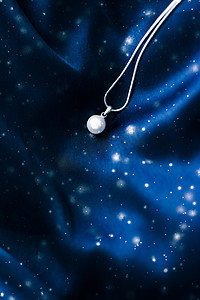 深蓝色丝绸上的豪华白金珍珠项链，假日冬季魔法珠宝礼物