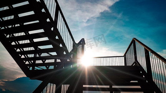 美丽蓝天背景阳光下的室外铁楼梯黑色钢结构建筑