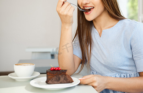 中午，年轻迷人的白人女士喜欢在现代咖啡店里吃巧克力蛋糕和热咖啡。