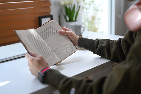秋日时光摄影照片_和平的男人阅读最喜欢的文学作品，在冬季或秋季周末在家度过休闲时光的裁剪图像