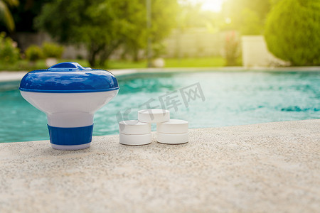 投用摄影照片_带氯分配器的片剂，适用于游泳池。