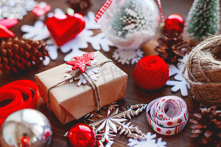 雪花新年摄影照片_圣诞节和新年背景与礼物、丝带、球和木制背景上的不同装饰。