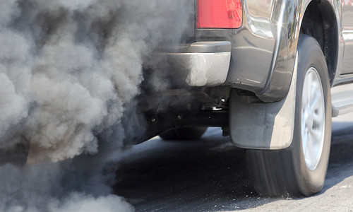 汽油燃烧摄影照片_道路上汽车排气管造成的空气污染