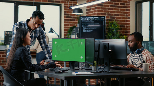 两名软件开发人员分析源代码，与坐在办公桌前的同事一起查看绿屏色度键模型