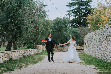 幸福时尚微笑的夫妇在婚礼当天在意大利托斯卡纳散步。