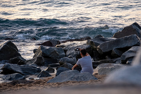 海滩上的摄影师架起相机，等待摄影的好时机