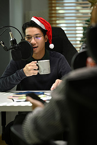 电台主持人使用麦克风和笔记本电脑在家庭工作室录制播客的图片。