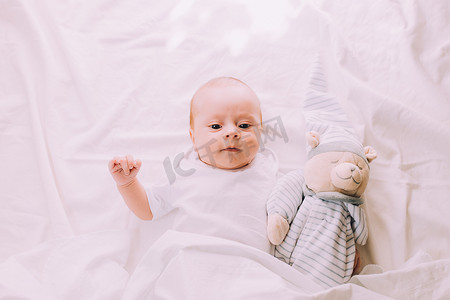 婴儿躺在他的婴儿床里，看着相机。