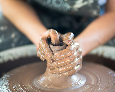 女人在轮子上制作陶瓷，手特写，陶瓷器皿的创作