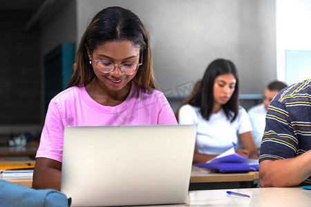 非洲裔美国大学生在课堂上使用笔记本电脑。青少年女性黑人高中生做作业。