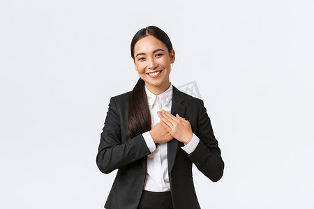 快乐的亚洲女企业家爱她的客户，因出色的工作而受到赞扬而感到受宠若惊，手握心，微笑着感恩，心存感激，欣赏努力