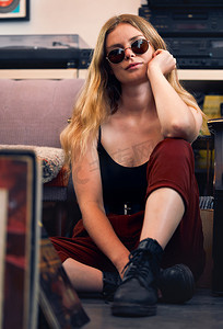 城市朋克摄影照片_朋克女人、垃圾时尚和摇滚嬉皮士、复古模特和地板上戴着眼镜的自信女性。