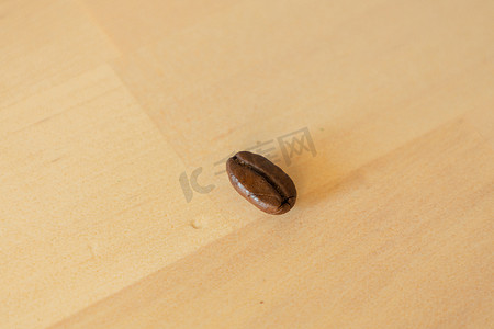 棕色咖啡豆背景摄影照片_木质背景下烤咖啡豆的特写