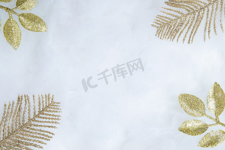金色雪花背景图摄影照片_装饰性的金色树枝在雪地上闪闪发光，复制空间平躺。