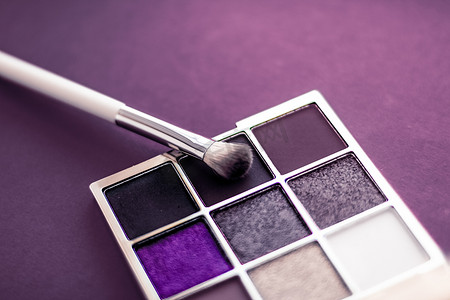 紫色背景的眼影调色板和化妆刷、作为奢侈美容品牌推广的眼影化妆品和假日时尚博客设计