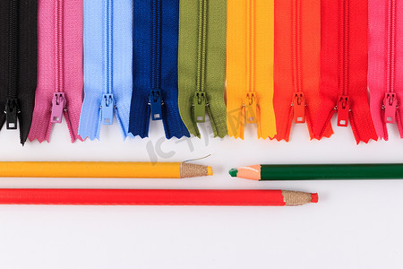 彩色拉链和铅笔在白色背景。
