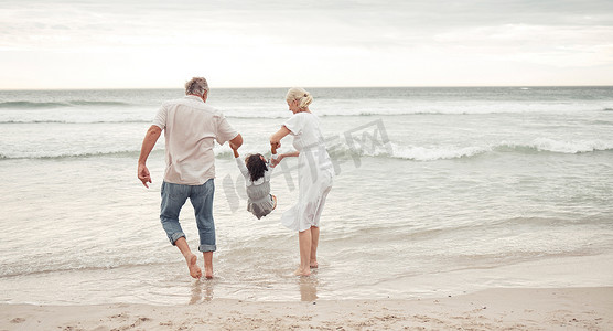 家庭、儿童和海滩与一个女孩和她的祖父母在海边或海洋的大自然中。