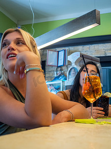 白人和拉丁裔女性朋友在酒吧喝雪碧和可乐