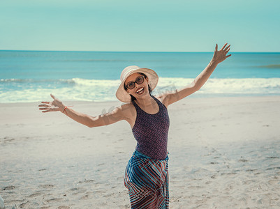 戴帽子的女人在海滩上快乐，快乐的漂亮年轻女人度假，度假概念