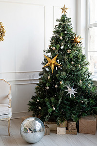明亮通风的客厅里放着礼物和灯的圣诞树