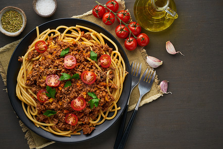 肉酱布卡提尼意大利面配肉末和西红柿，深色木质背景，顶视图，复制空间