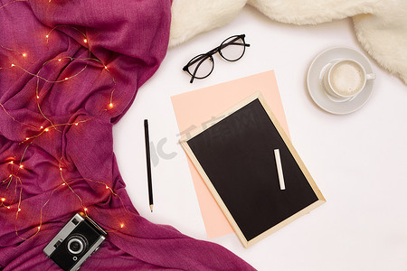一杯咖啡、一块黑色小木板和写有新年目标的白色粉笔。