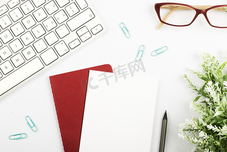 关于一张纸的重要公告在桌上的记事本上，有花、眼镜、笔、热饮和键盘。