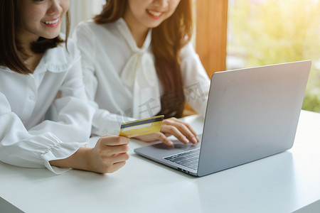 在线购物和互联网支付，美丽的亚洲女性正在使用信用卡和笔记本电脑在数字世界中在线购物或办事