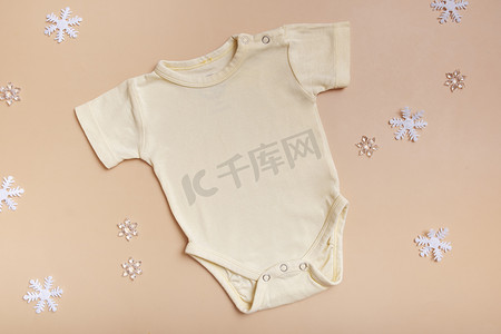 黄色婴儿紧身连衣裤样机，用于标志、文字或粉红色背景设计，带有冬季装饰顶视图。