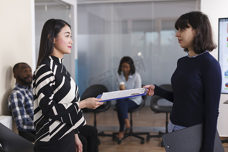 亚洲失业妇女向人力资源经理提供简历以获得面试机会。