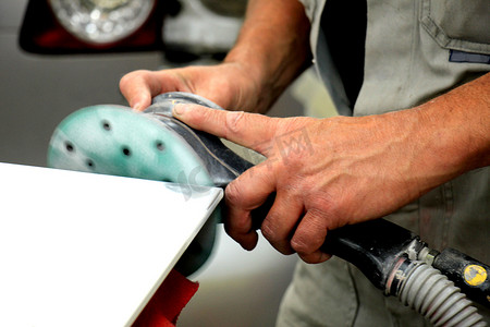 汽车修理店的男人用磨床打磨汽车零件