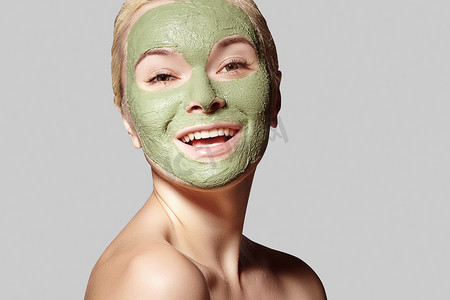 应用绿色面膜的美丽女人。