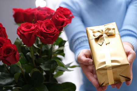 快递员手中的红玫瑰花束和金色礼盒