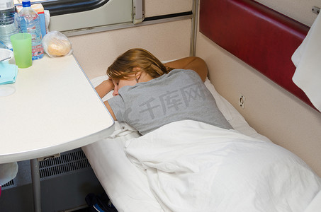 火车上女孩在二等车厢下层车厢趴着睡，双手枕在头后