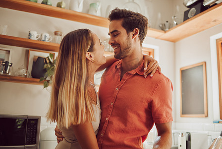 浪漫、幸福、充满爱的情侣在厨房里拥抱、微笑和结合。