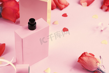 国色天香logo摄影照片_打开粉红色背景上的香水瓶。
