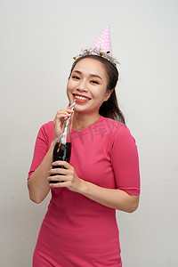 美丽的疯狂微笑女人的肖像，她用吸管从瓶子里喝白色的苏打水