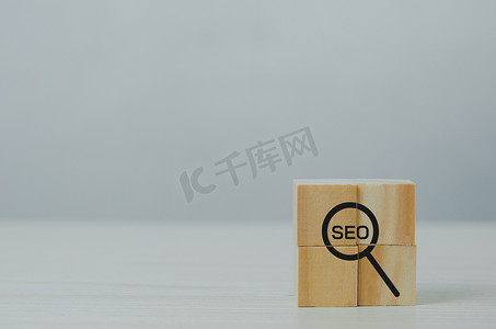 带放大镜图标和首字母缩写词 SEO 的木制立方体。数字营销策略 SEO 搜索引擎优化排名概念。