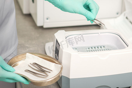 用医疗器械清洁系统对镊子进行手消毒。