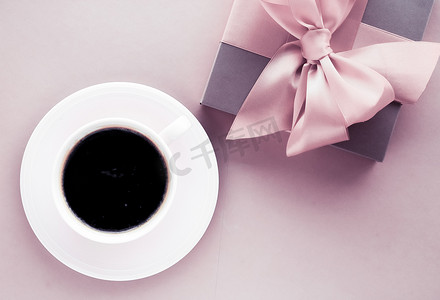粉红色背景的豪华礼盒和咖啡杯，浪漫假期和生日惊喜的平面设计