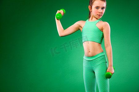 绿色背景下做健身运动的小女孩