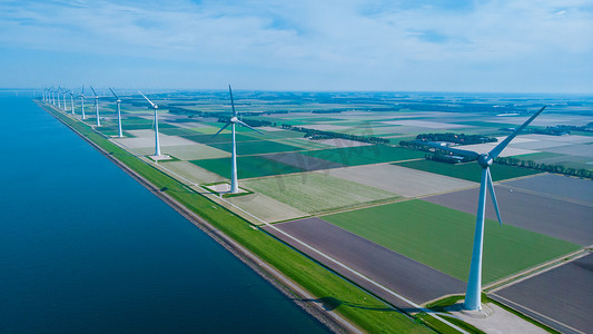 产生原因摄影照片_海洋中的风车公园，无人机鸟瞰产生绿色能源电力的风车涡轮机，荷兰海上隔离的风车