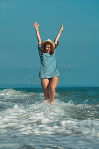 夏天海边的一个美丽女孩高兴地在水上玩耍，情绪激动