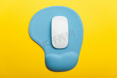 蓝色垫或带有无线白色电脑鼠标的鼠标垫