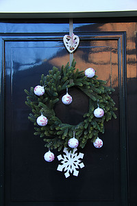 圣诞花环摄影照片_经典的圣诞花环，门上有装饰