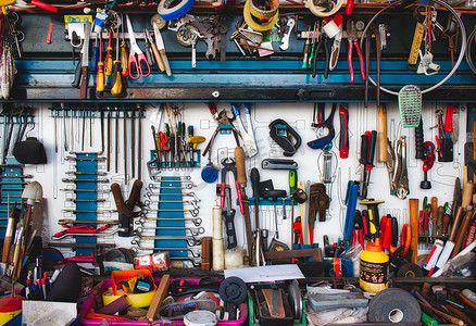 墙上挂着各种工具，车库里有工作台